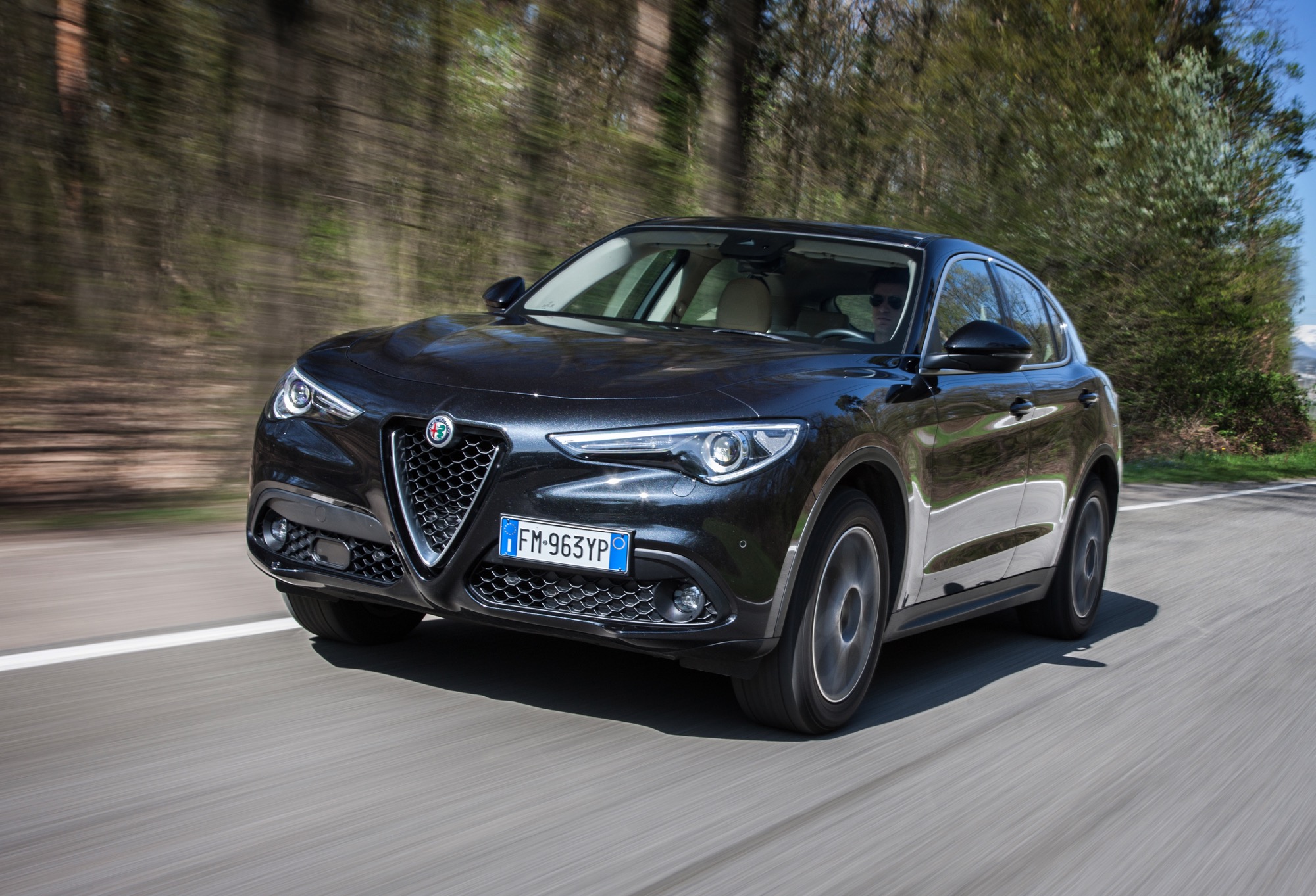 Alfa Romeo Stelvio 3/4 laterale anteriore sinistra in movimento su strada nera